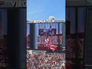 Skydiver with a giant flag hooked to his rig hits the scoreboard in a packed stadium