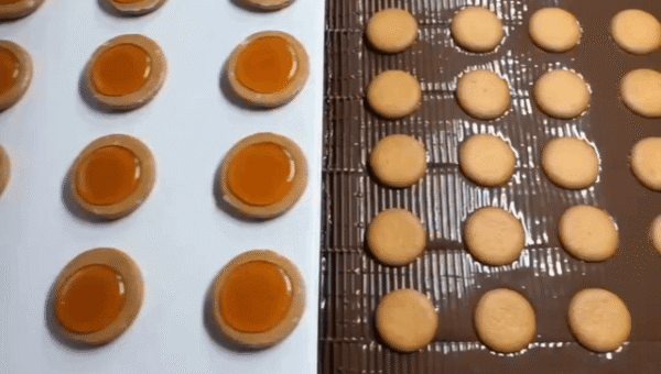 Jaffa Cakes falling off a conveyor belt for their chocolate coating