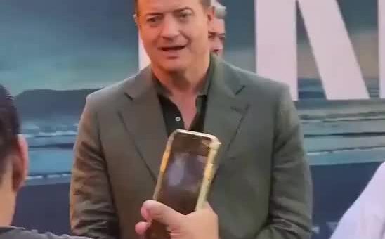 Brendan Fraser patiently helps a fan trying to take a photo with him