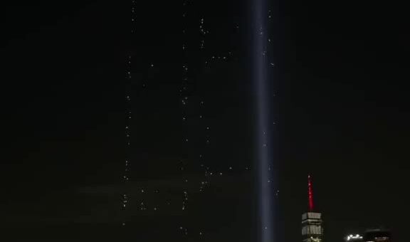 2,977 drones rose over New York Harbor to rebuild the Twin Towers in light. One…